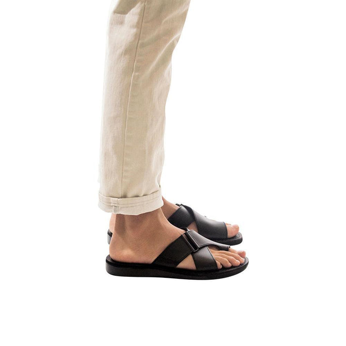 Model wearing Asher black, handmade leather slide sandals with toe loop