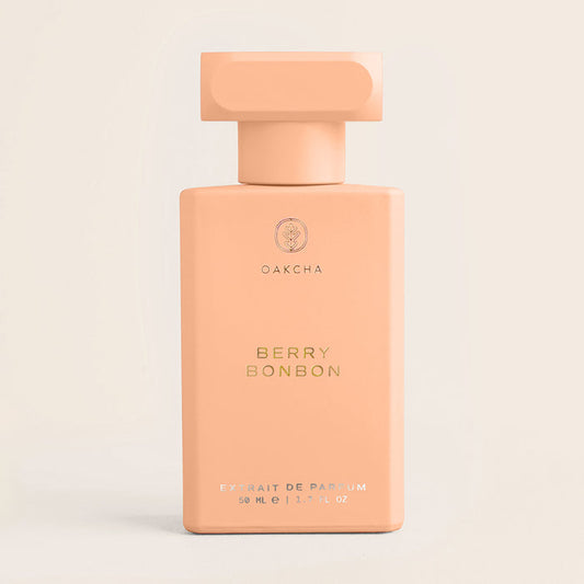 Front view of Berry Bonbon perfume bottle showcasing matte peach rectangular bottle and gold embossed label with soft beige background