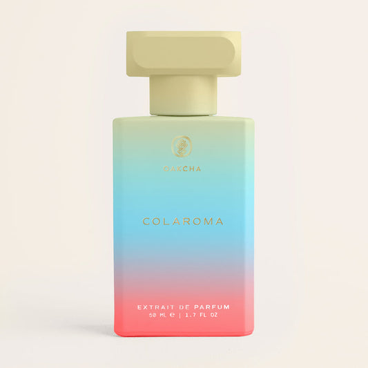 Front view of Colaroma perfume bottle showcasing pastel blue-to-pink gradient glass and gold cap against a cream background