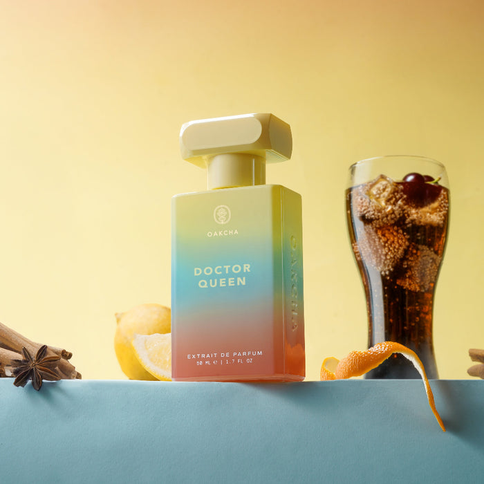 Front view of Dr Queen pump bottle showcasing gradient teal to orange label and pump dispenser with soft yellow backdrop