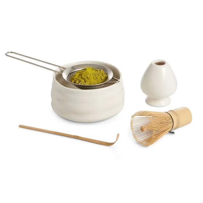 Tea-making set with ceramic container, whisk, and spoon on a white background