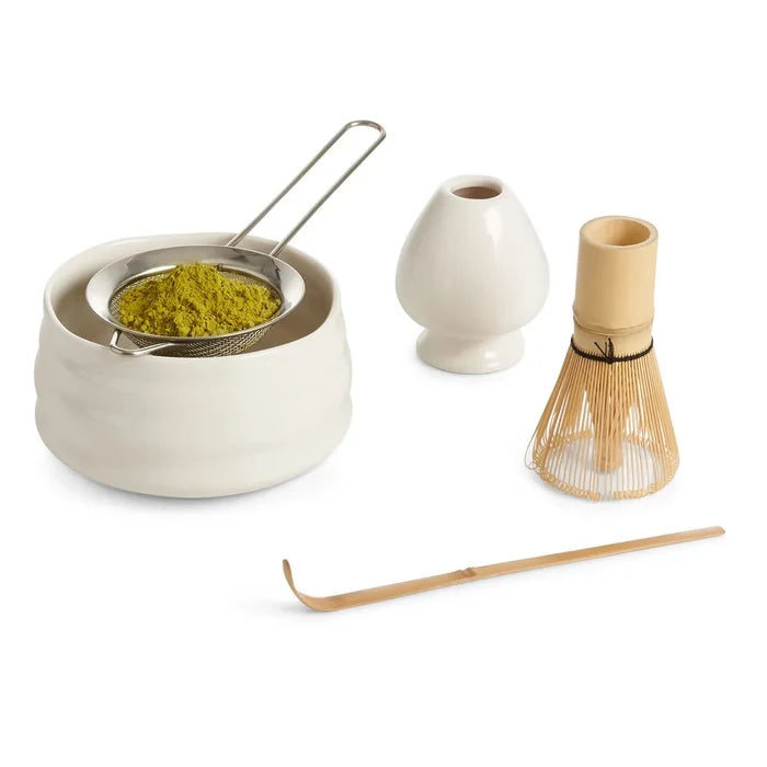 Matcha preparation set with ceramic bowl, whisk, scoop, and container on a white background