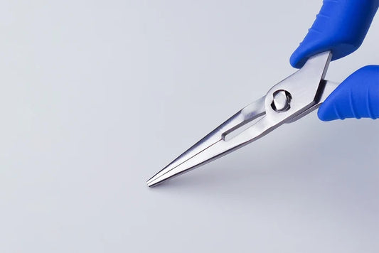 Pair of Straight Fish Bone Pliers held by a gloved hand on a light gray background