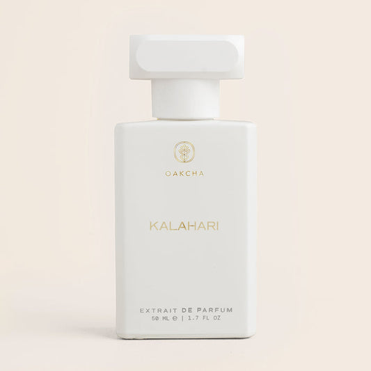 Front view of Kalahari unisex perfume bottle showcasing white rectangular bottle with gold lettering and T-shaped cap on soft beige background