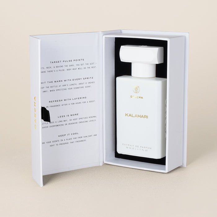 Front view of Kalahari perfume bottle in open white presentation box, white rectangular bottle with white cap on beige background