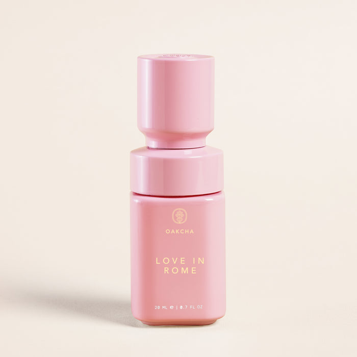 Front close-up of Love in Rome perfume bottle, pink with gold Oakcha logo and ‘Love in Rome’ text, 20 ml