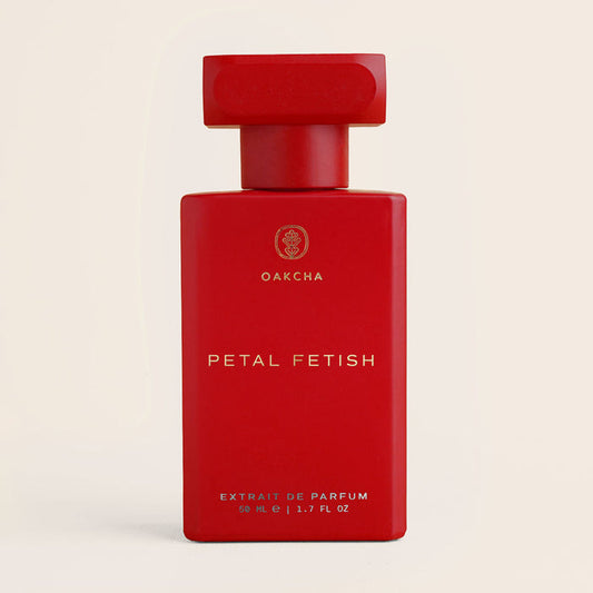 Front view of Petal Fetish perfume showcasing matte red rectangular bottle with gold logo and red cap on cream background