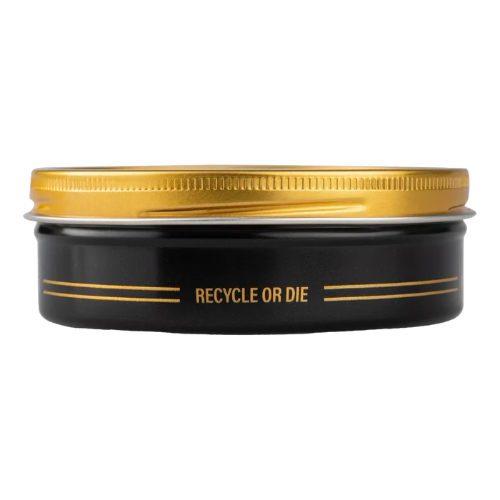Reuzel Severed Head Strong Hold Clay i svart metallboks med gullfarget lokk og 'RECYCLE OR DIE'-tekst