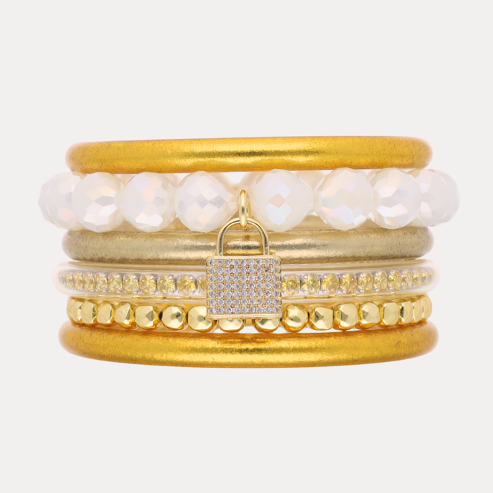 a stack of gold and white bracelets