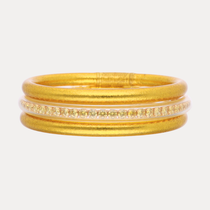 Set of gold bangles on a white background