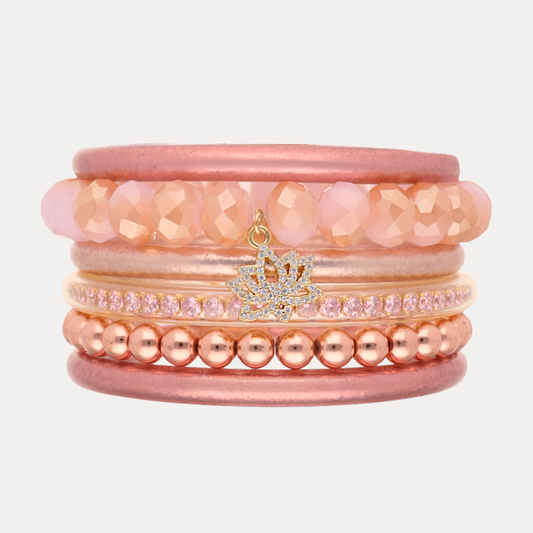 a stack of pink and gold bracelets
