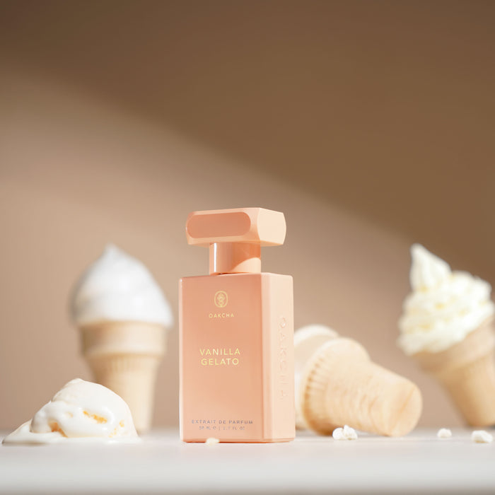 Front of Vanilla Gelato bottle with peach-pink rectangular body and gold cap on beige background with ice cream cones