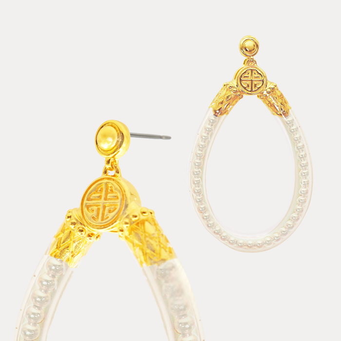 a pair of earrings with a gold and white pearl design